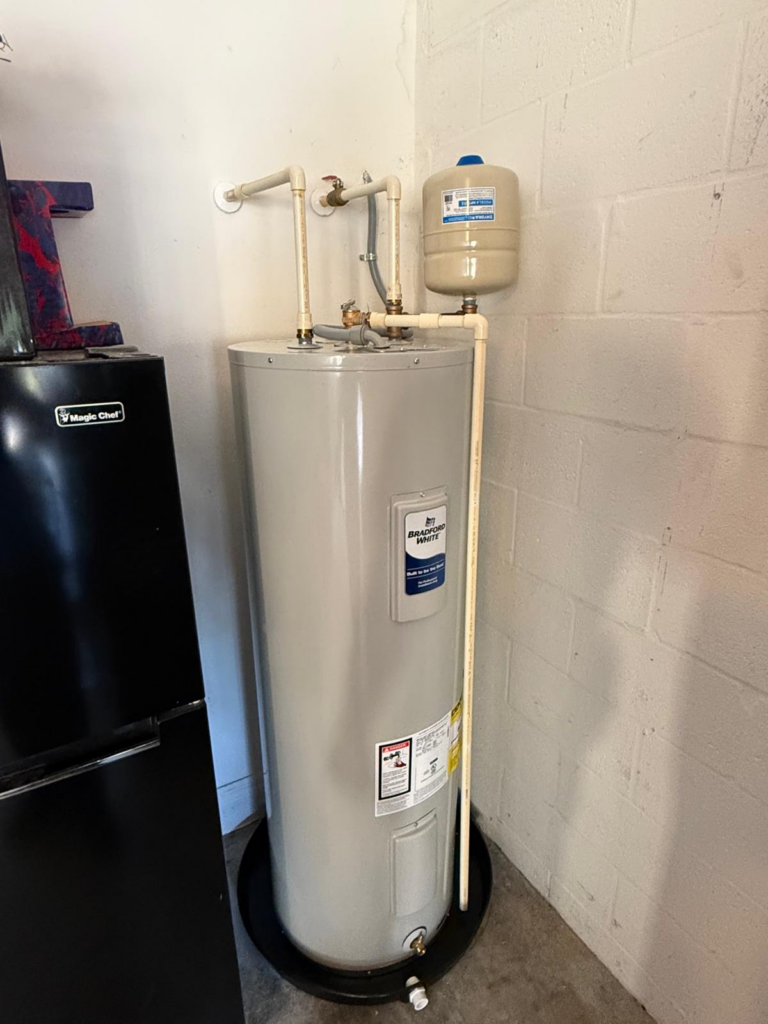 Bradford White residential hot water heater with expansion tank professionally installed in a utility room.